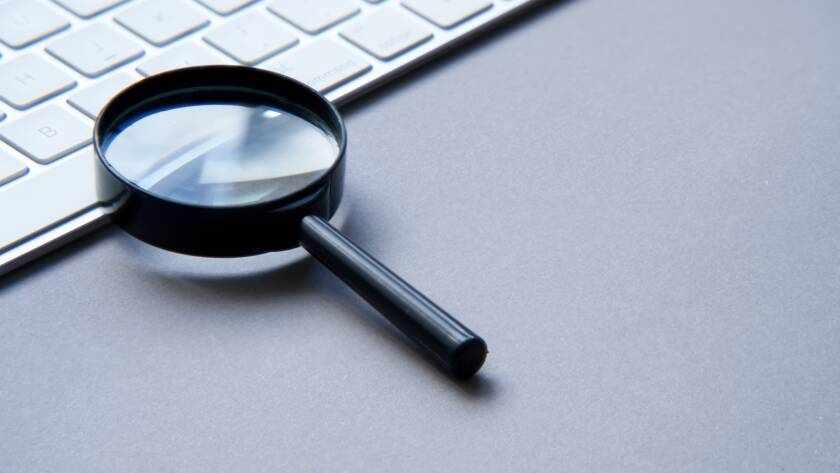 Search engine optimization. Keyboard and magnifying glass.