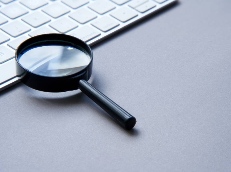 Search engine optimization. Keyboard and magnifying glass.